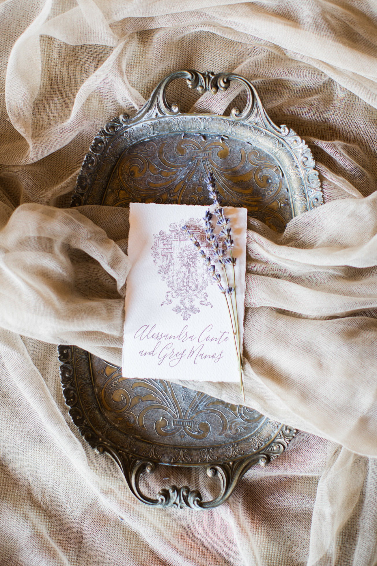 Beautiful intricate wedding invitation calligraphy styled by professional photographer and designer for bride and groom and photographed on vintage textures and fabrics.