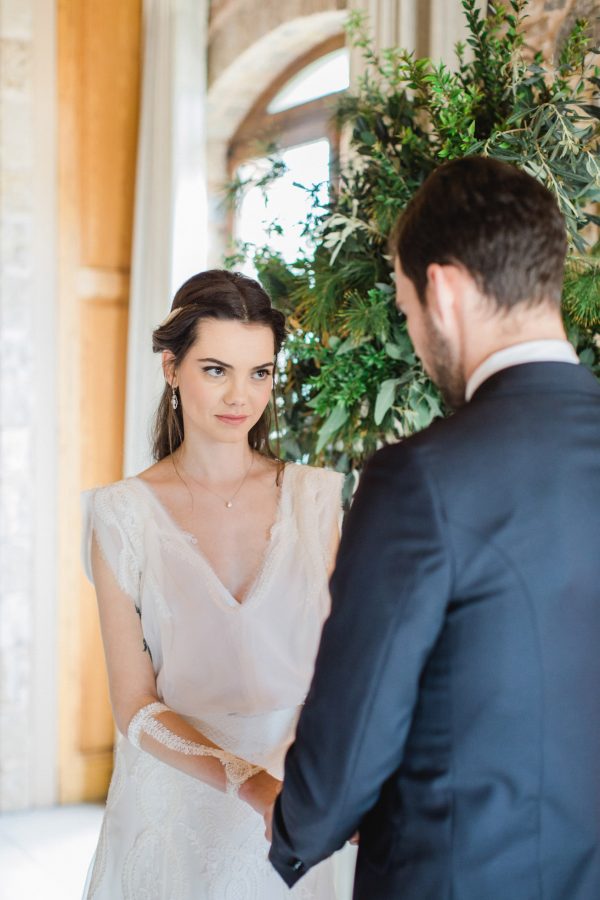 Bride and groom during their wedding ceremony reading their wedding vows surrounded by the decorations of Pyrgos Petreza in Athens.