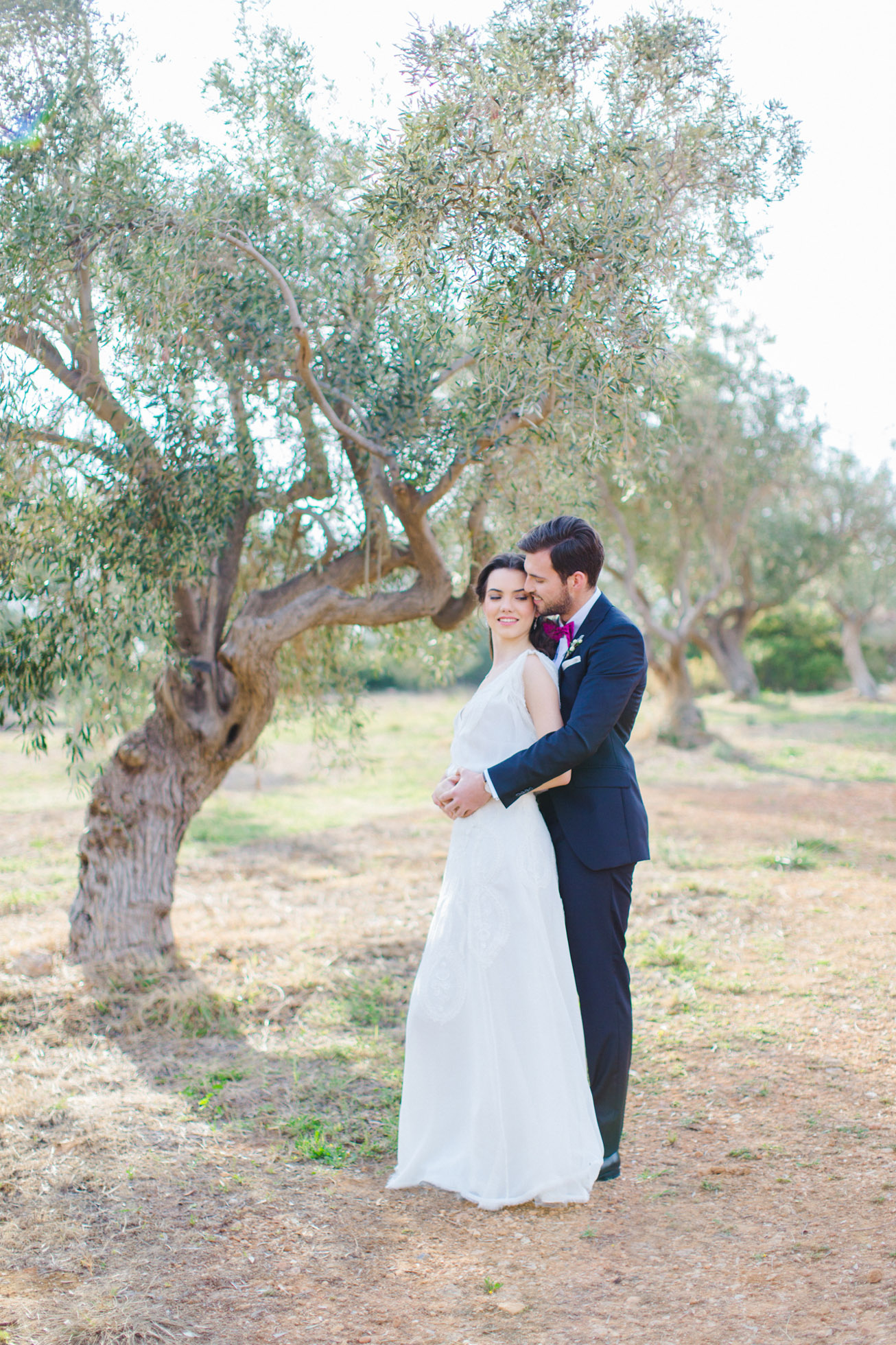 Bride and groom posing for elegant wedding day portraits with the backround of Pyrgos Petreza estate in Athens.