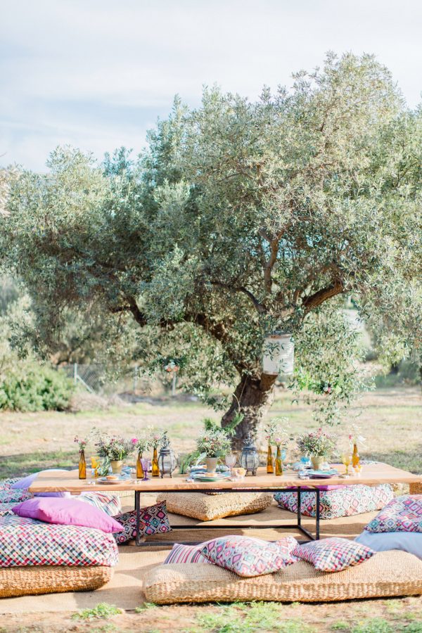 Wedding day garden reception set up with colorful plates, seasonal flowers and personalized place cards in Pyrgos Petreza Athens.
