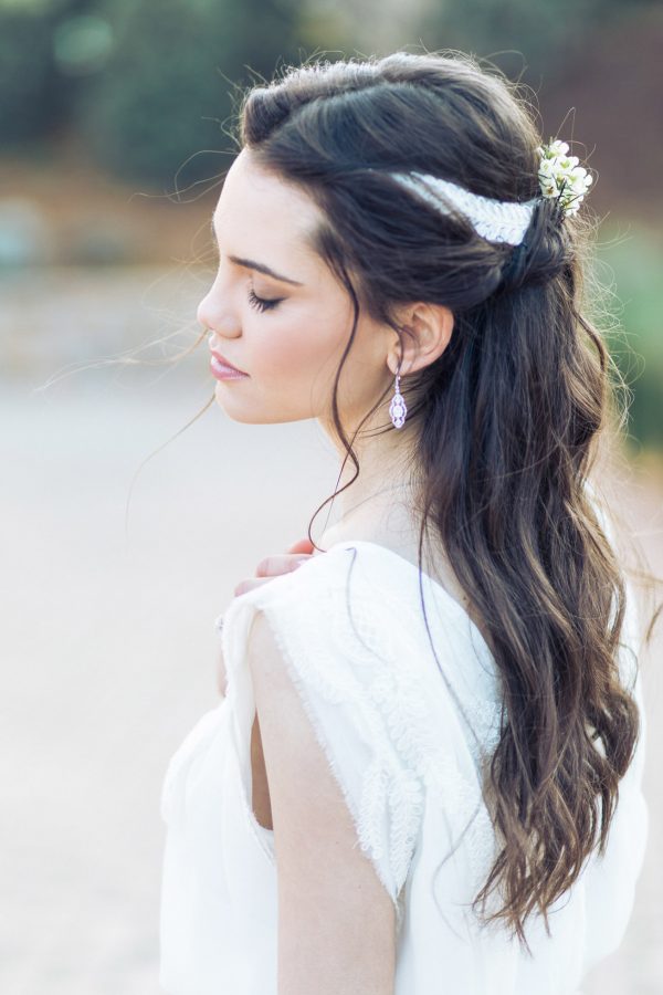 Bride in her wedding dress, hair and make-up and diamond jewellery posing for professional wedding day portraits in Athens.