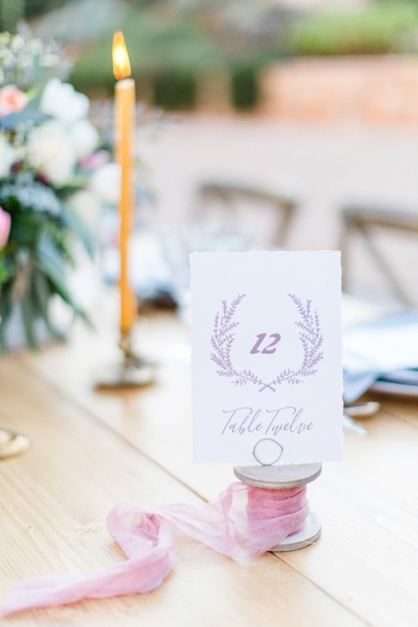 Wedding day dinner reception set up with delicate details, elegant plates, seasonal flowers and personalized place cards styled and photographed in Pyrgos Petreza Athens.