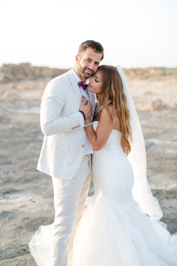Professional Crete wedding photoshoot, bride and groom posing for the wedding photographer at the beach in Chania Crete.