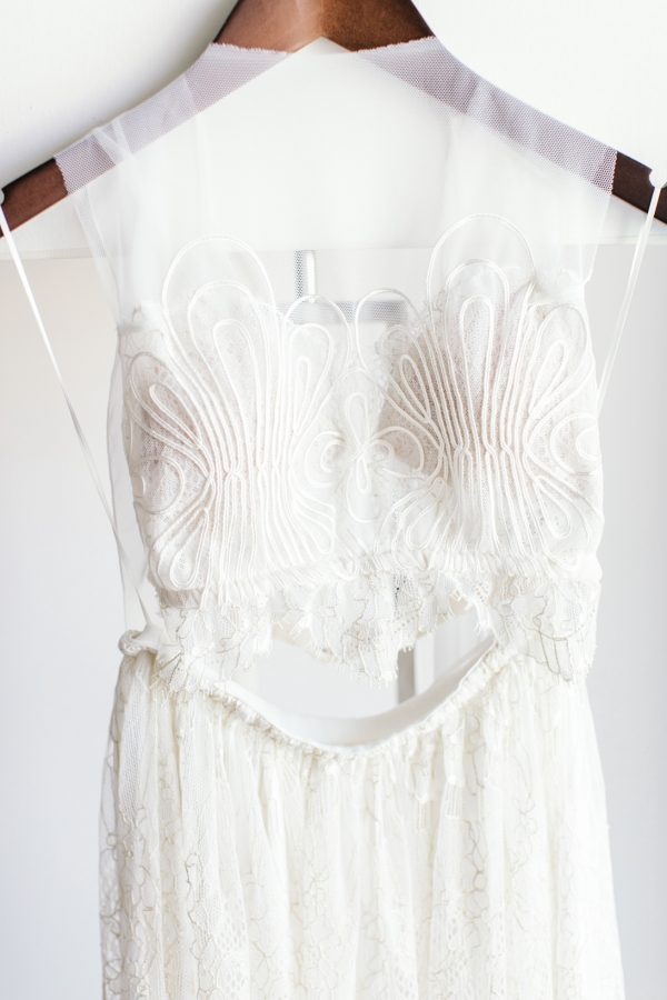 Intricate detail of a two piece boho bridal wedding gown photographer over delicate white background.