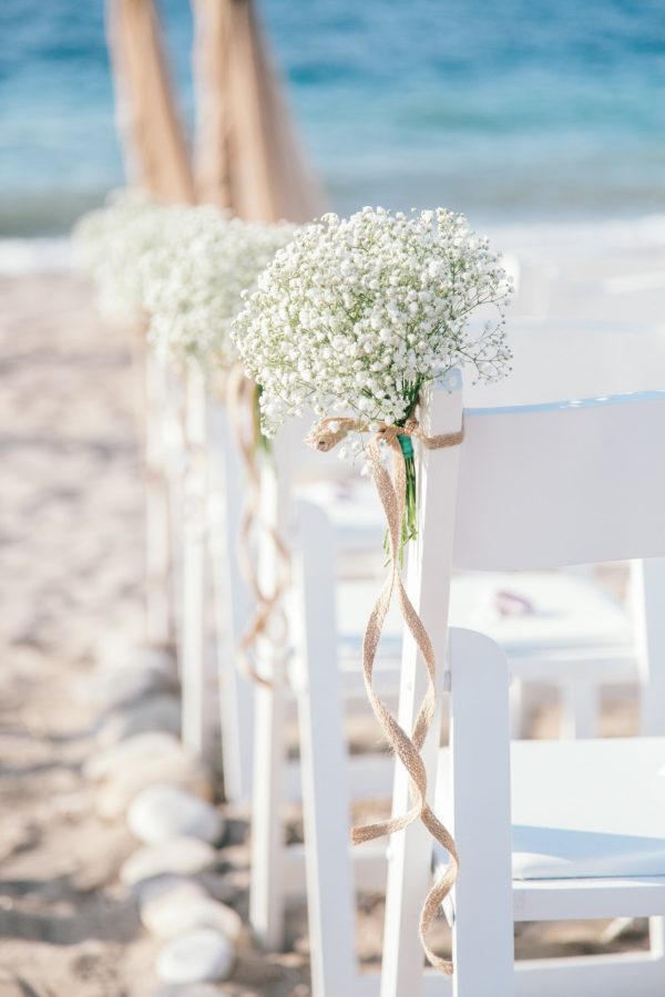 Beach ceremony set up in natural tones and fabrics for a symbolic ceremony planned and coordinated by a local wedding planner and photographed professionally.