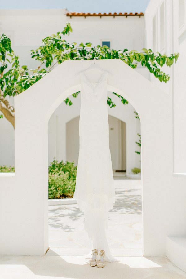 Pronovias bridal wedding dress hanging from a whitewashed doorway in Caramel luxury hotel in Crete.
