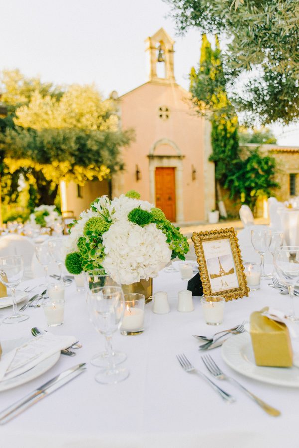 Detail of luxury elegant dinner reception set up in green, white and gold at Grecotel Agreco wedding estate in Crete captured before the arrival of guests and the grand entrance.