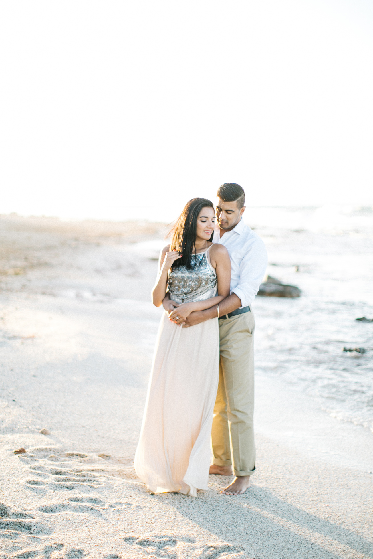 Engaged couple posing on the beach in Crete during their pre wedding engagement photosession at sunset.
