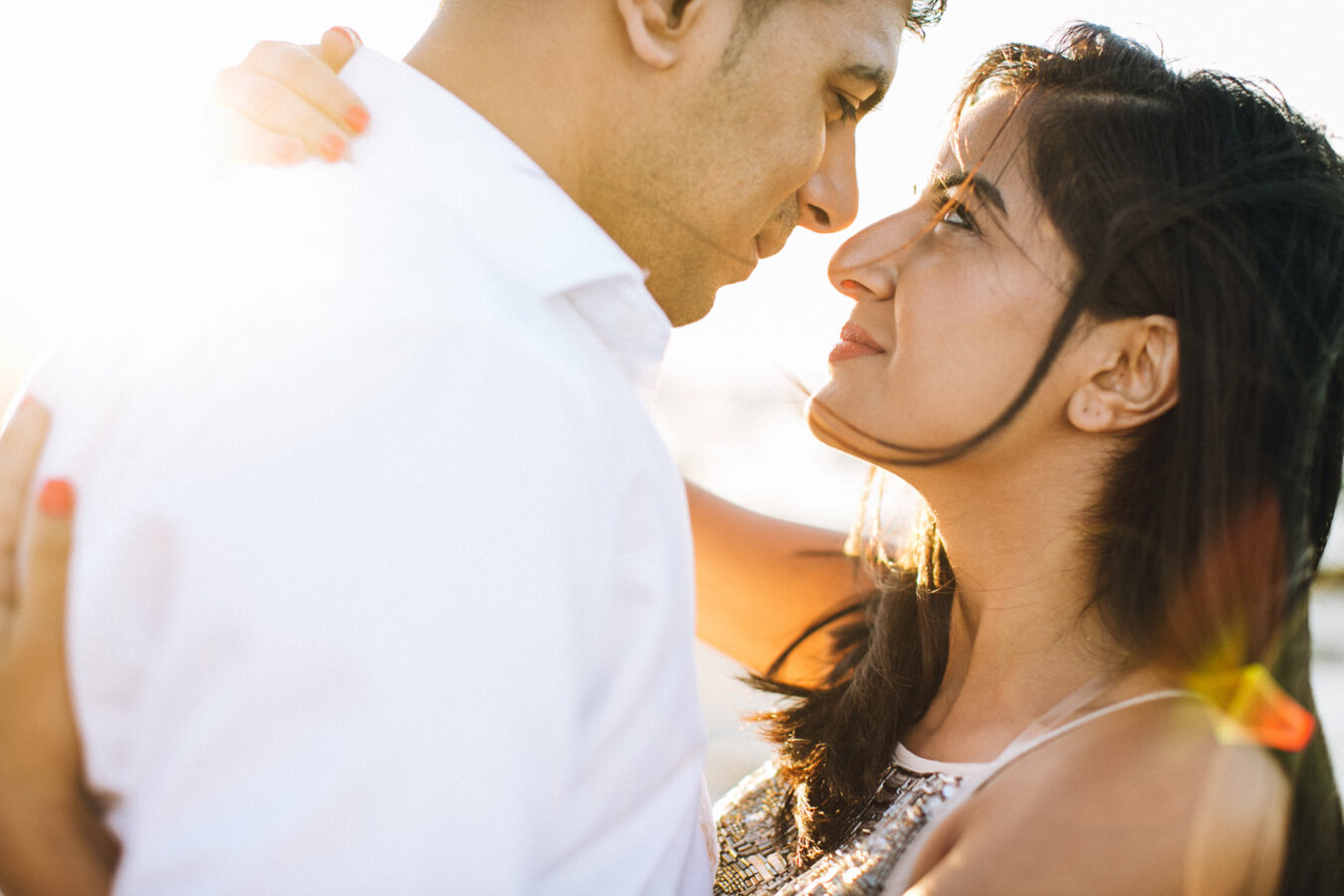 Close up portrait of an engaged couple posing on the beach in Crete during their pre wedding engagement photosession at sunset.