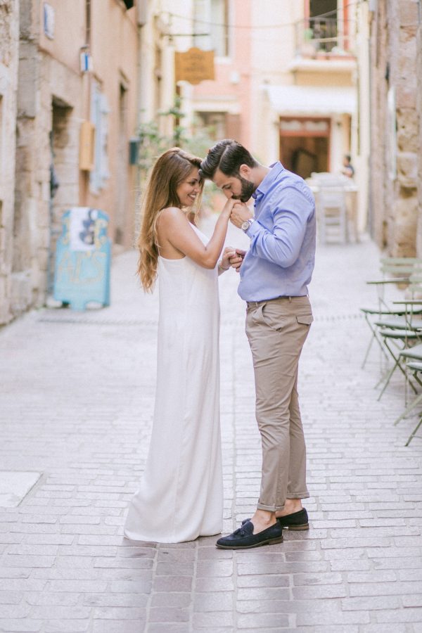 beautiful couple posing for professional photographer in the old town of Chania Crete with rich background of Greek architecture.