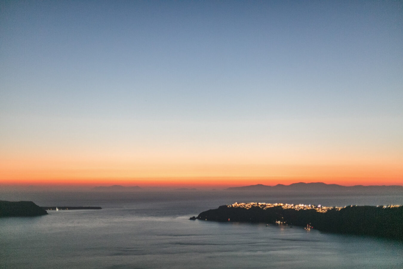Sunset view of Oia Santorini captured by professional photographer from the caldera terraces of Imerovigli village.