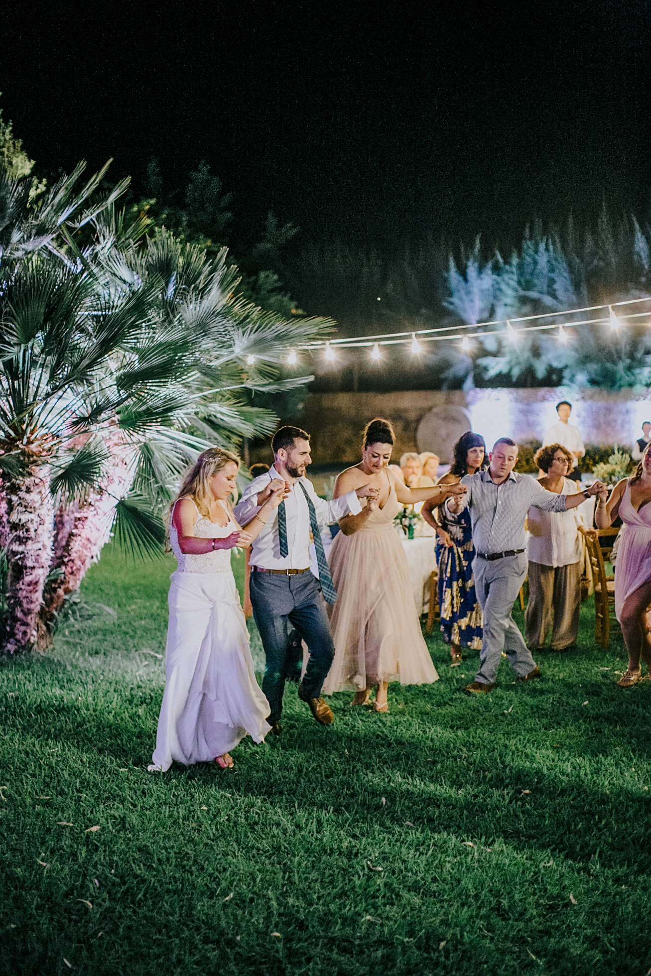 Bride and groom dancing traditional Greek dances on an exclusive wedding night in Metohi Kindelis, Chania, Crete photographed by professional photographer team.