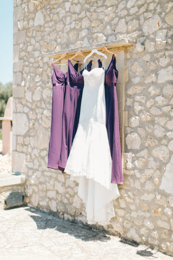 Bridal gown and bridesmaids' dresses in white and purple photographed in Agreco farm during destination wedding in Crete.