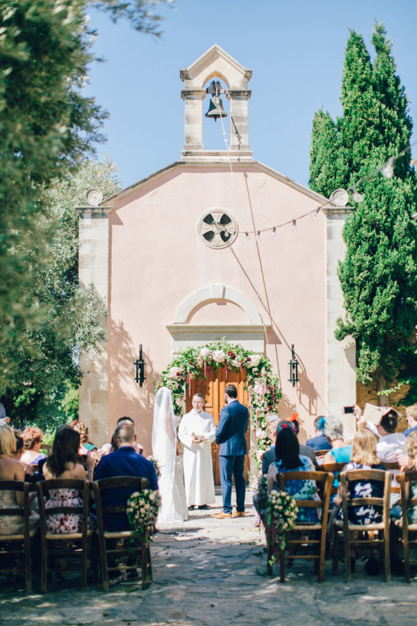 Candid image of an elegant bride and groom getting married in Agreco Farm in Crete, Greece, captured by their wedding photographer.