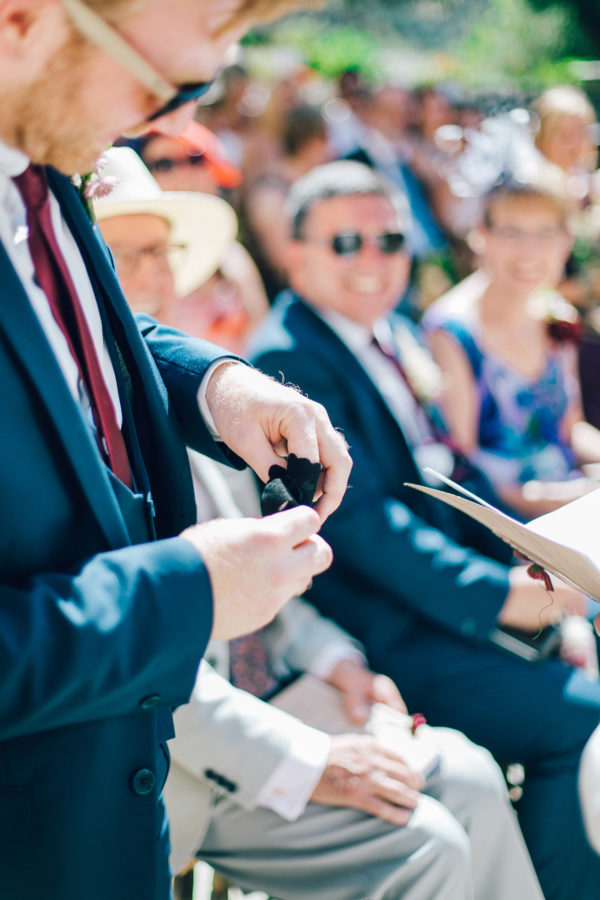 Candid image of a best man reaching for the wedding rings on a destination wedding day in Agreco Farm in Crete, Greece, captured by wedding photographer.