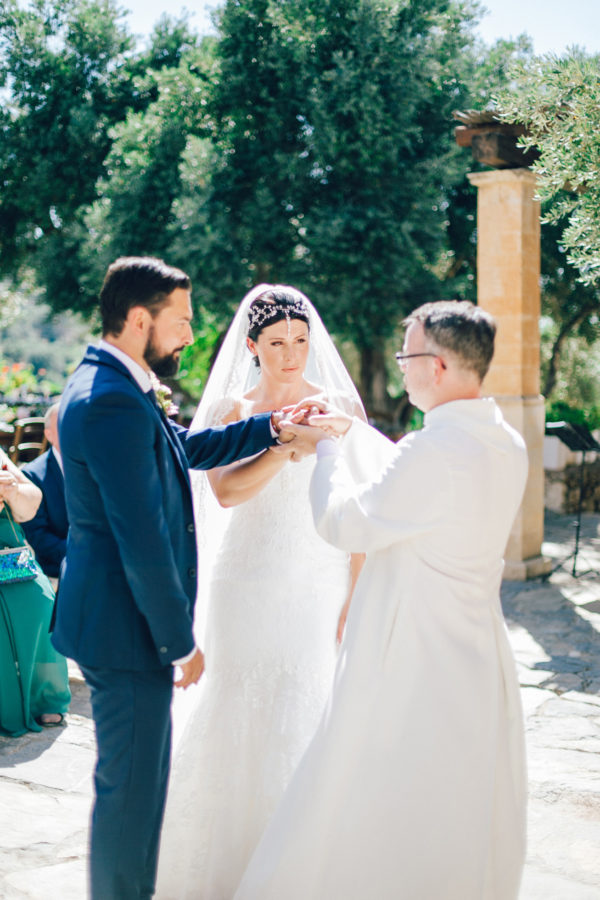 Candid image of an elegant bride and groom getting married in Agreco Farm in Crete, Greece, captured by their wedding photographer.