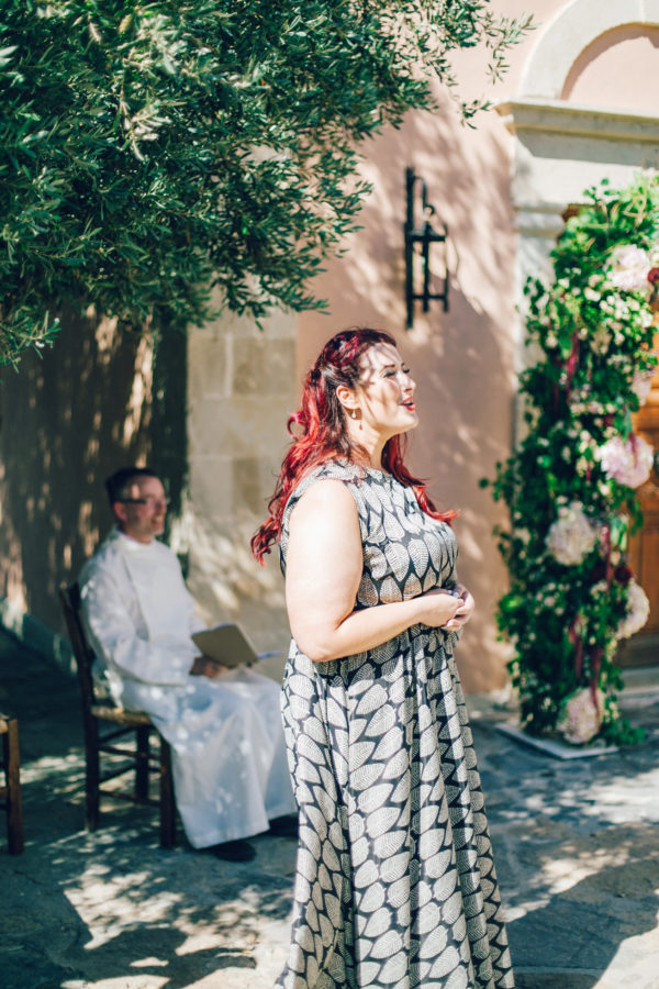 Candid image of a wedding singer performing for the newlyweds on a destination wedding day in Agreco Farm in Crete, Greece, captured by wedding photographer.
