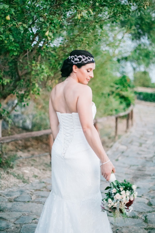 Stunning bride posing for portraits for her photographer on a destination wedding day in Agreco Farm, Crete.
