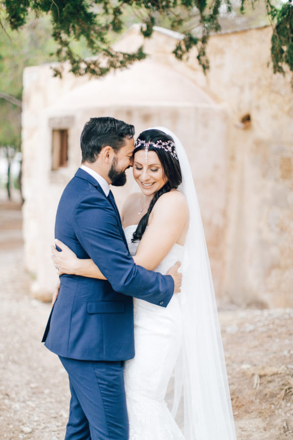Fine art wedding portraits of the newly wedded couple posing for professional destination wedding photographer at Fortezza of Rethymno in Crete, Greece.