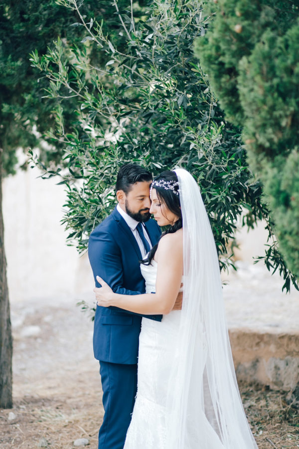 Fine art wedding portraits of the newly wedded couple posing for professional destination wedding photographer at Fortezza of Rethymno in Crete, Greece.