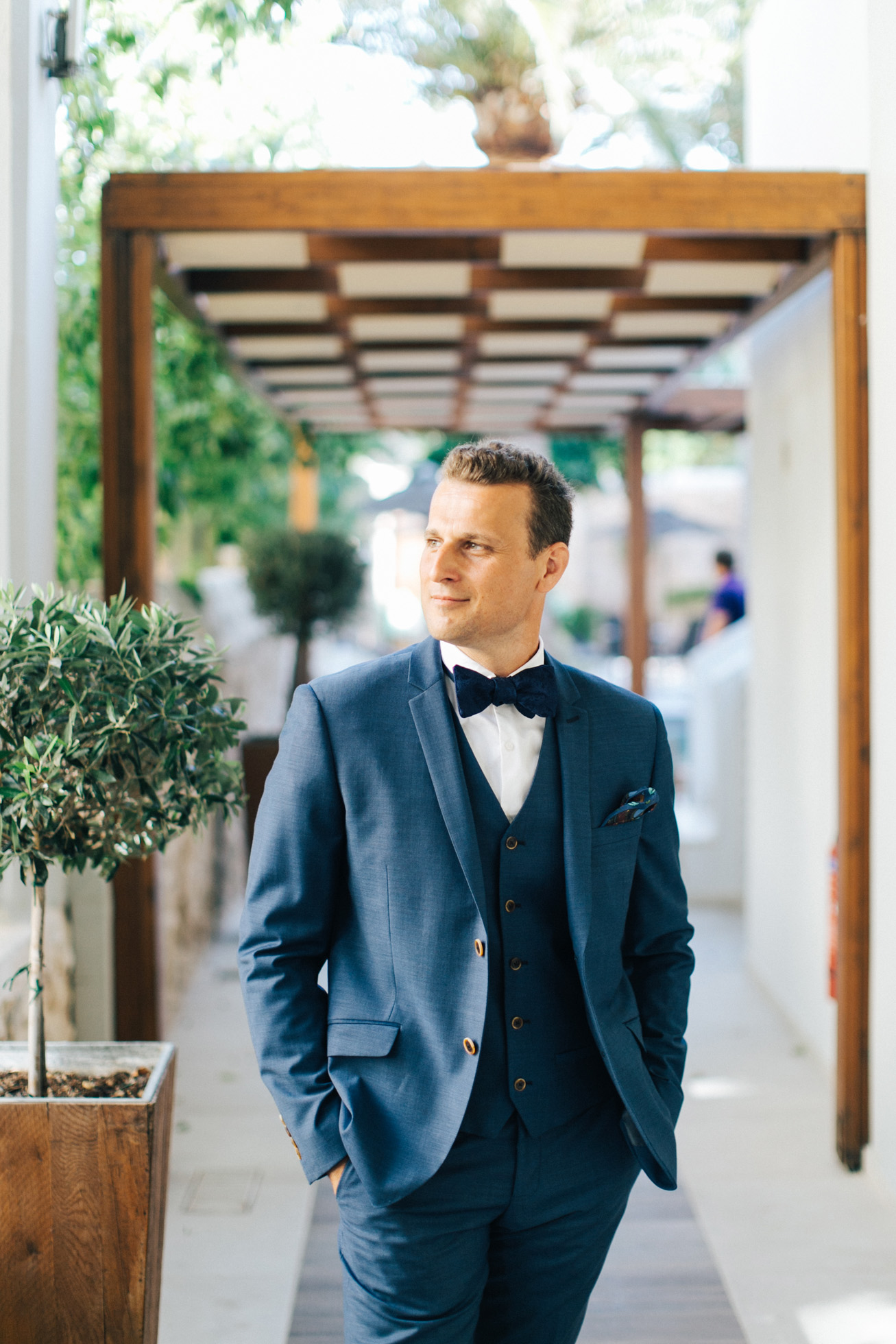 Portrait of an elegant modern groom on his wedding day in Crete posing for professional photographer.