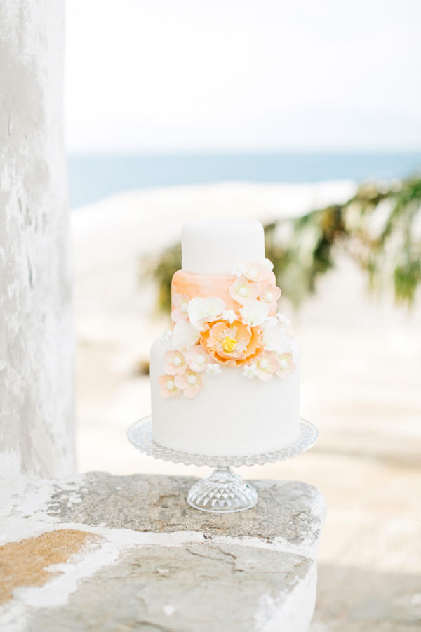 Wedding cake with a background of Mykonos windmill stones.