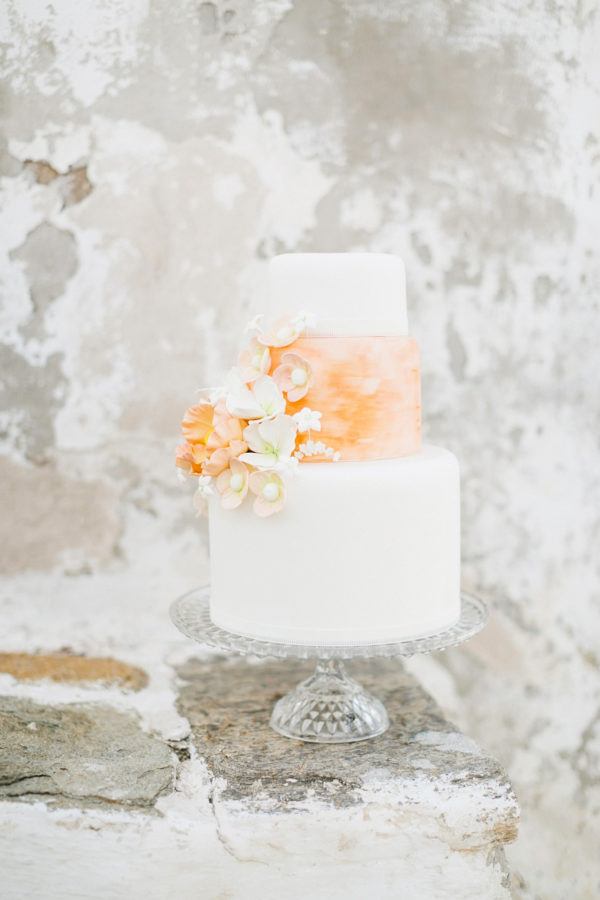 Wedding cake with a background of Mykonos windmill stones.