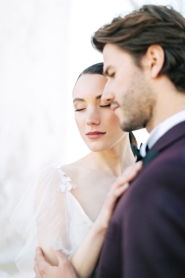 Stylish bride and groom on their destination wedding in Mykonos, posing under the windmills.