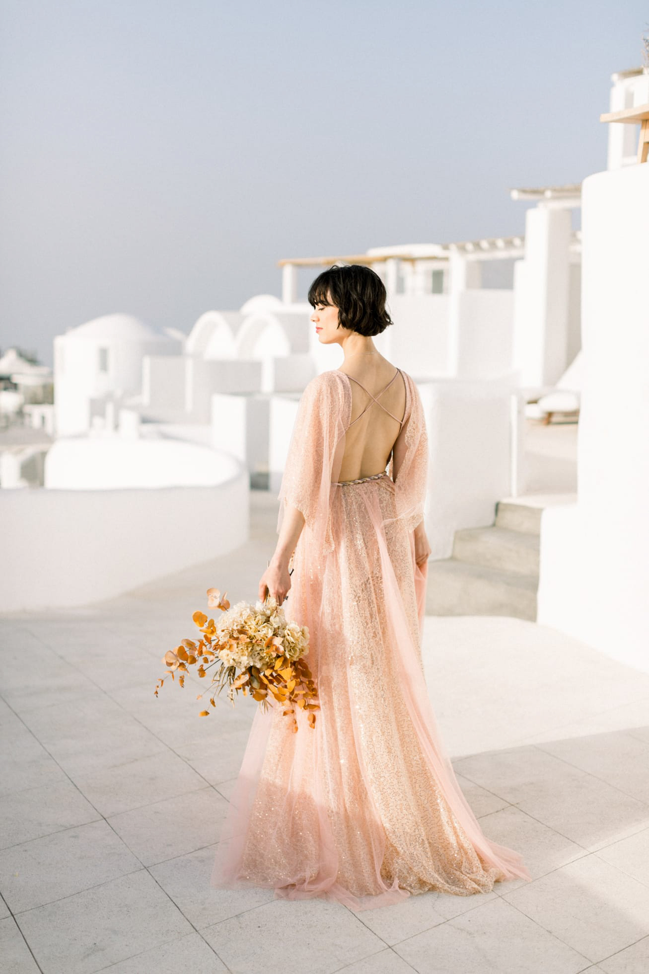 Dreamy and poetic Santorini bride wearing flowy designer wedding dress and diamond theme coordinated jewellery.