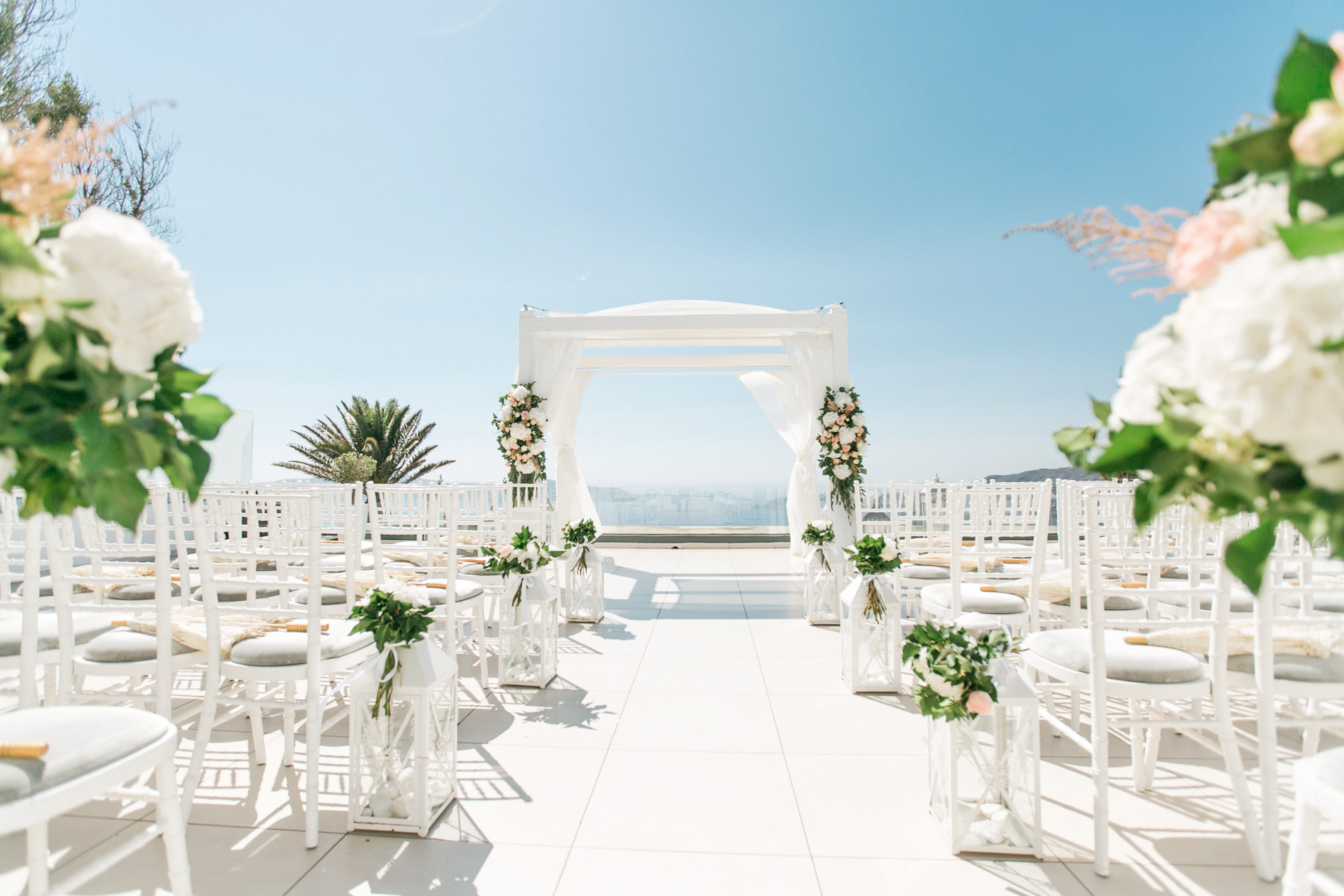 Wedding ceremony decoration and setup for luxury white wedding in Santorini island, Greece.