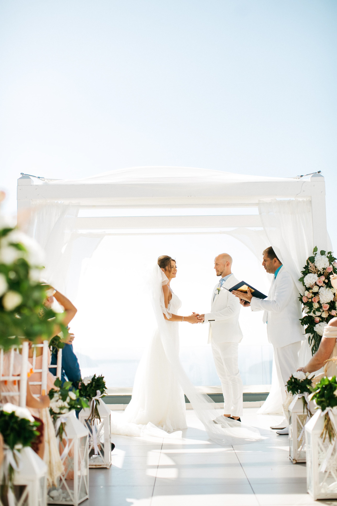 Bride and groom at their wedding ceremony at Le Ciel wedding estate in Santorini island, Greece.
