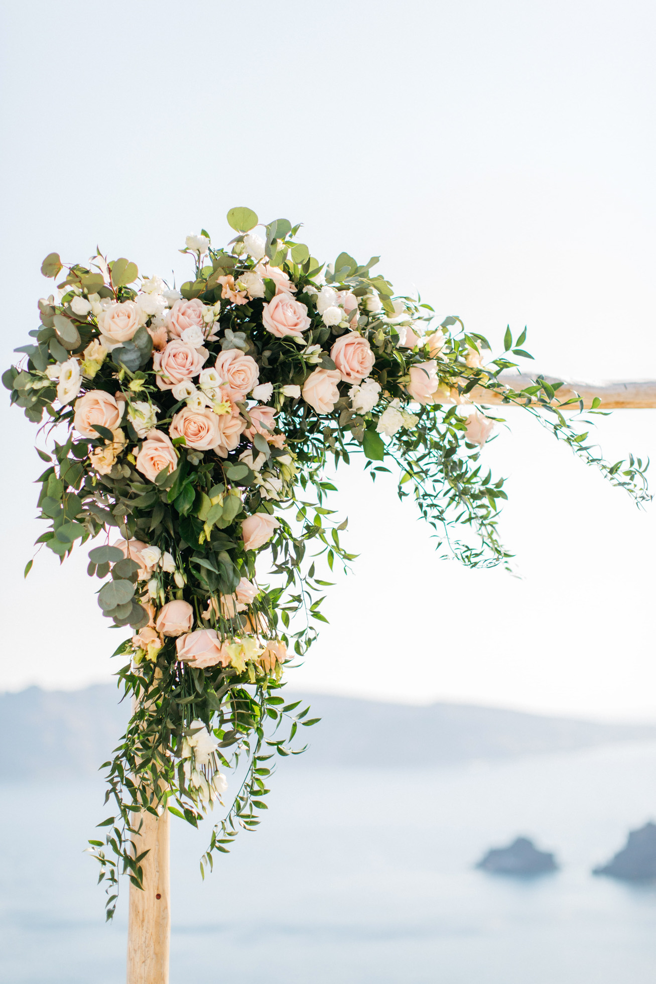 Flowery wedding arch and ceremony setup in Canaves Suites Oia Santorini.