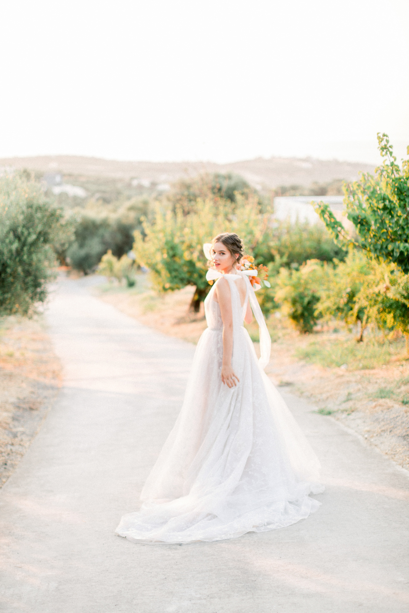 Stunning modern bride holding flowers at a sunset wedding editorial in Grecotel Agreco Farms Crete Greece as published on Ruffled blog.