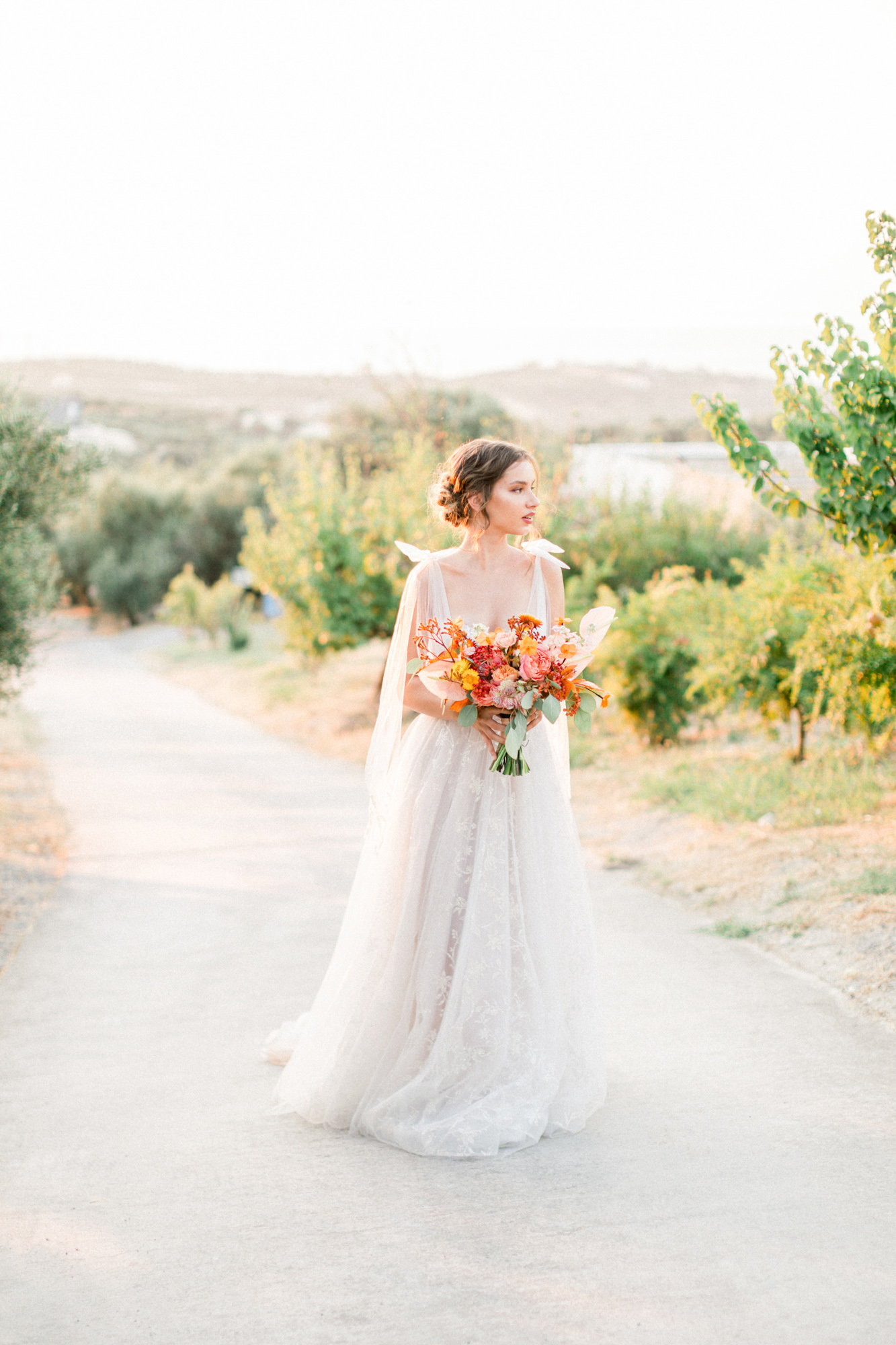 Stunning modern bride holding flowers at a sunset wedding editorial in Grecotel Agreco Farms Crete Greece as published on Ruffled blog.